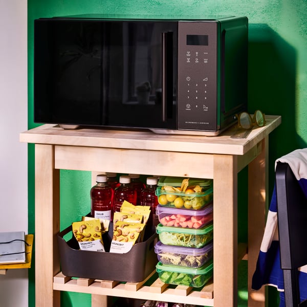 Freestanding GÅTEBO microwave oven/air fryer, a stack of purple and green PRUTA sandwich containers and ISKUB cashnew nuts.