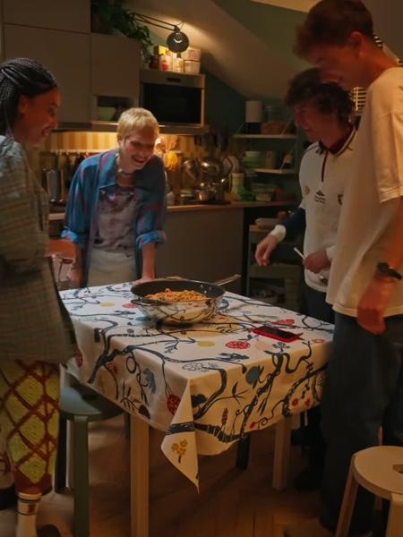 Un gruppo di amici condivide un pasto in allegria. Seduti attorno a un tavolo, ridono, parlano e si godono la compagnia, trasformando una semplice cena in un momento speciale di connessione. L'atmosfera è vivace e piena di energia positiva.