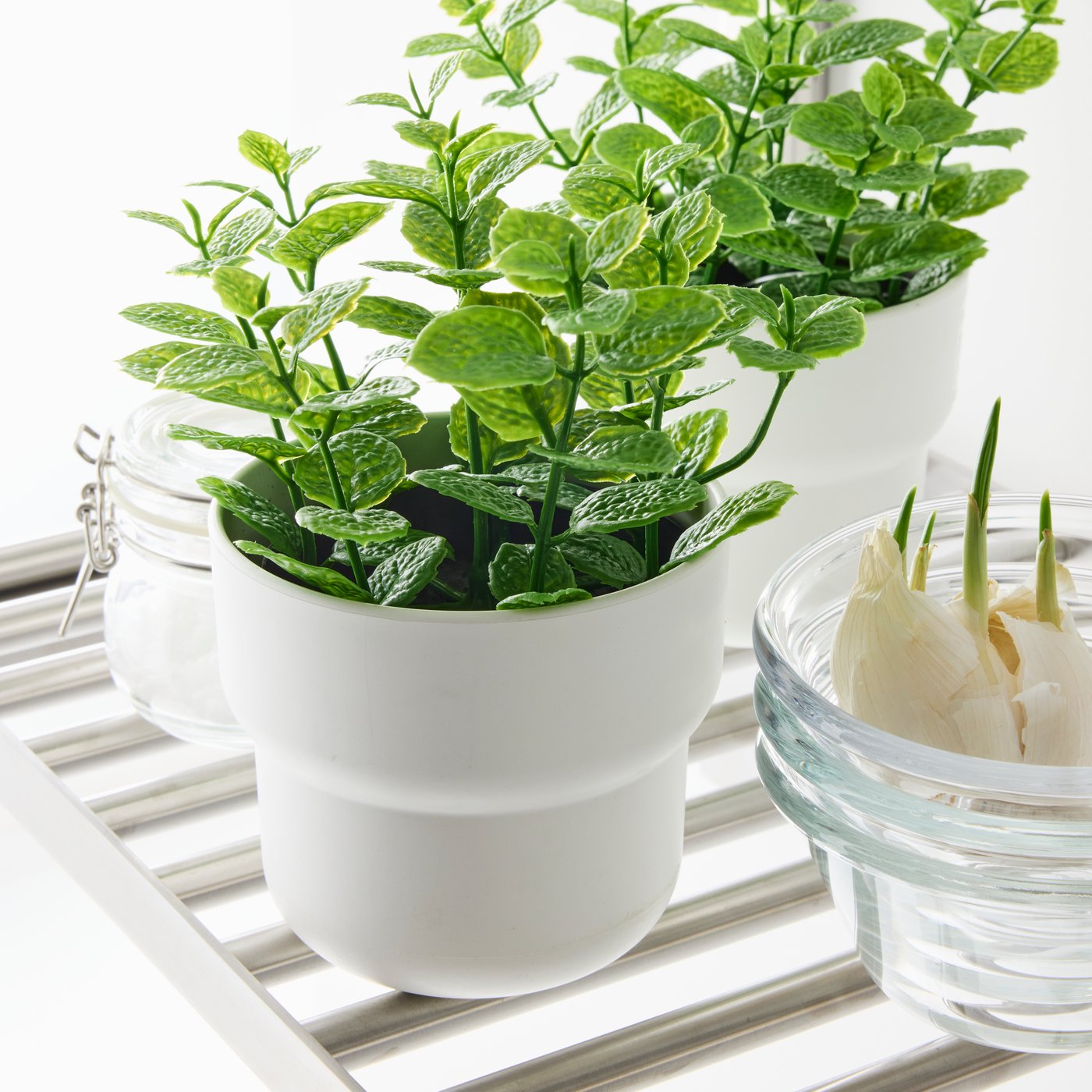 Lähikuva minttua esittävästä FEJKA-tekokasvista, joka on valkoisessa FÖRENLIG-ruukussa.