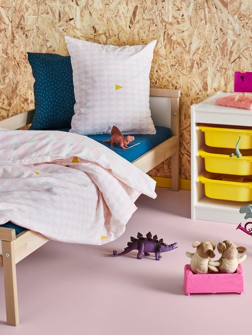  Children's room with a bed frame with guard rail with duvet cover and pillows, and a storage combination with boxes.