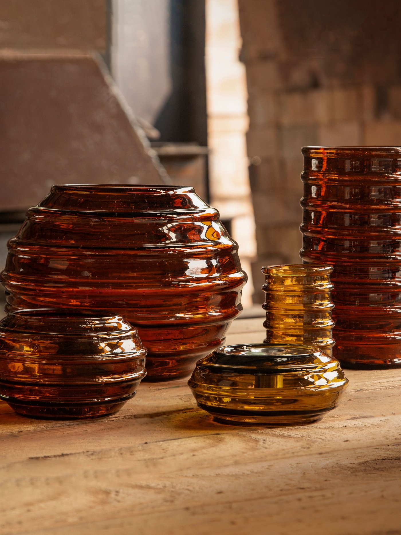 Braune HÄNGBJÖRK Vasen und Kerzenständer stehen auf einer Tischplatte.