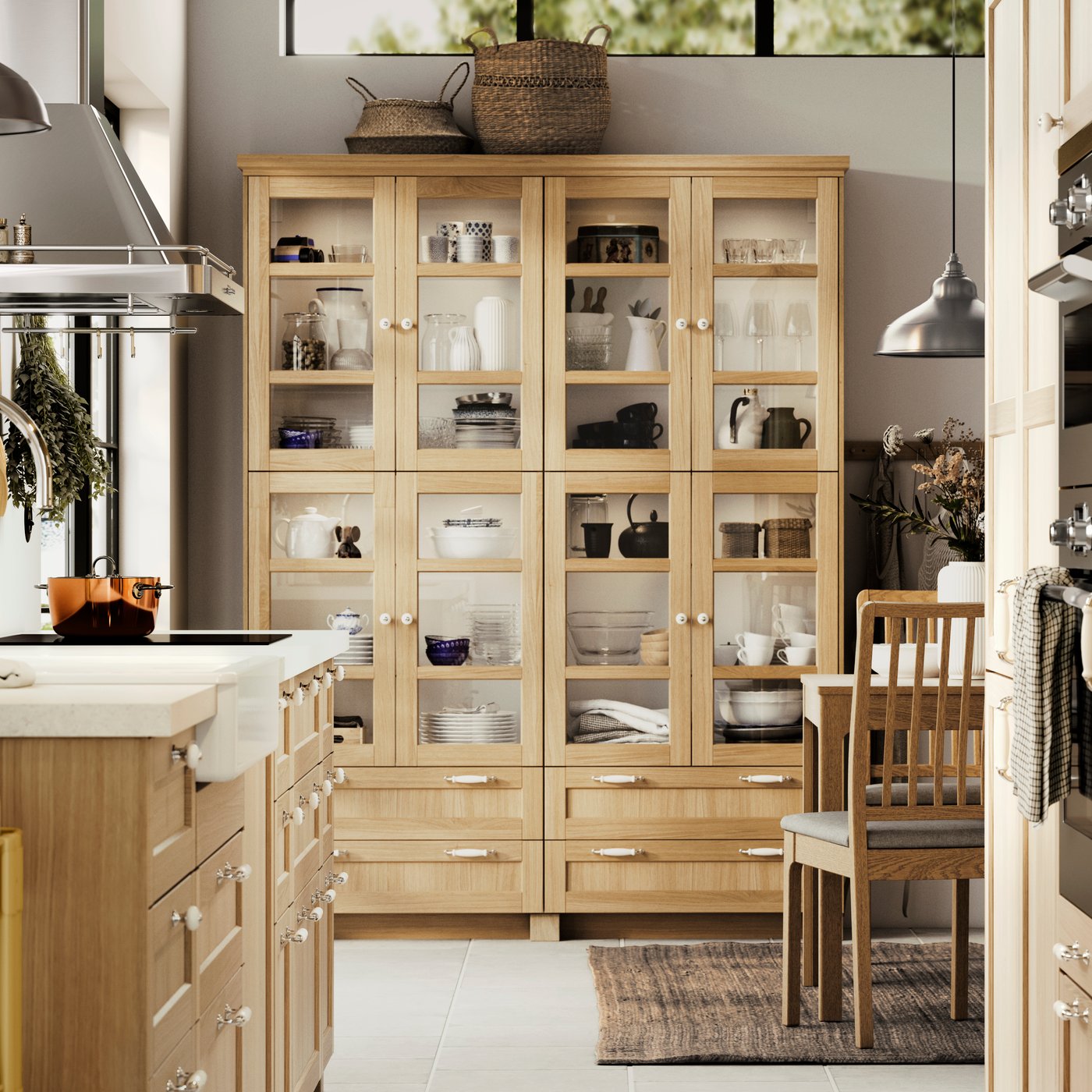 A kitchen with FORSBACKA fronts in oak veneer, a glass-door cabinet and a SÄLJAN worktop with white stone effect/laminate.v