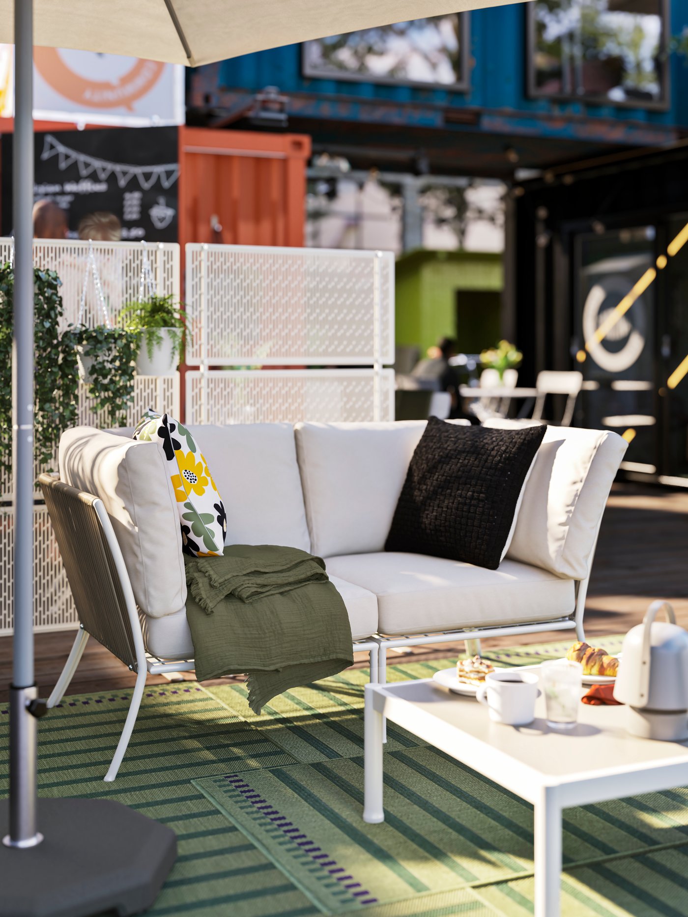 IKEA SEGERÖN outdoor sofa in beige with a metal and corded rope frame with big comfy beige outdoor seat cushions on a green outdoor rug