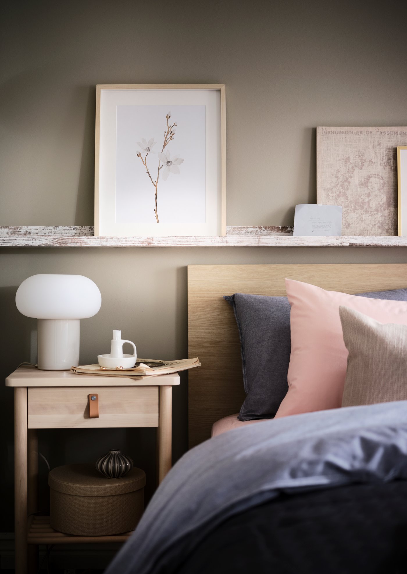 Cama con respaldo MALM junto a un velador BJÖRKSNÄS y una lámpara de mesa blanca DEJSA.