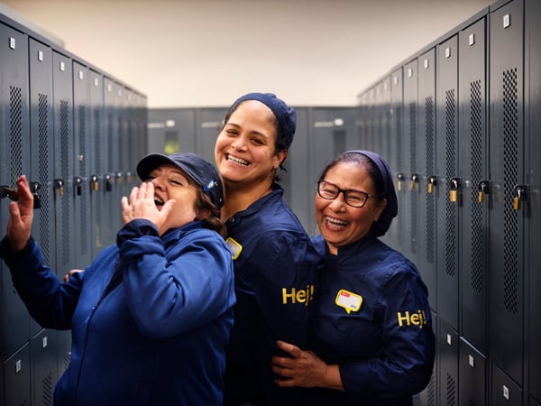 Tre persone che indossano una divisa IKEA sono all'interno di uno spogliatoio con tanti armadietti