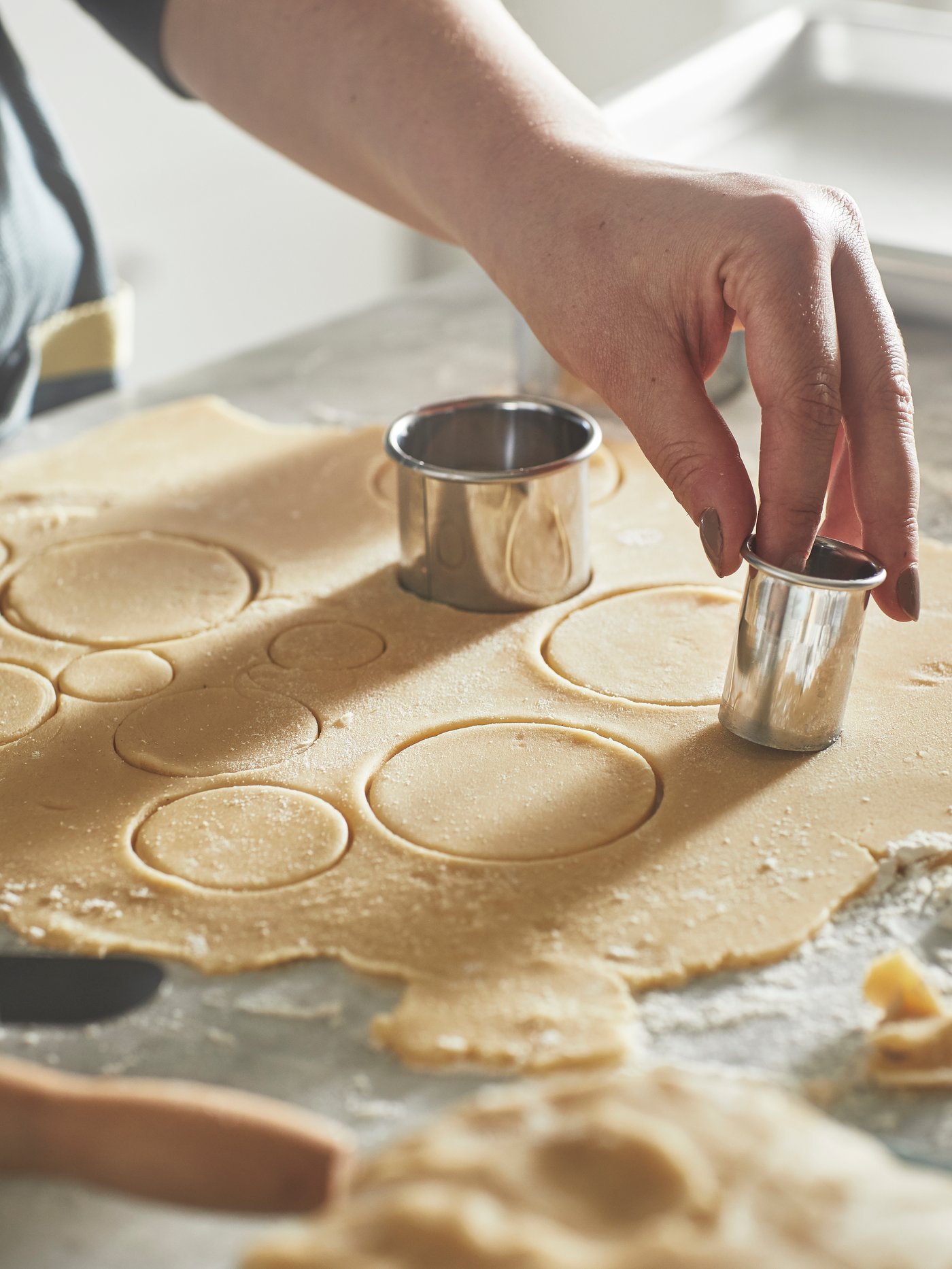 Una persona sta facendo dei biscotti di pasta frolla usando un tagliabiscotti LÄTTBAKAD.