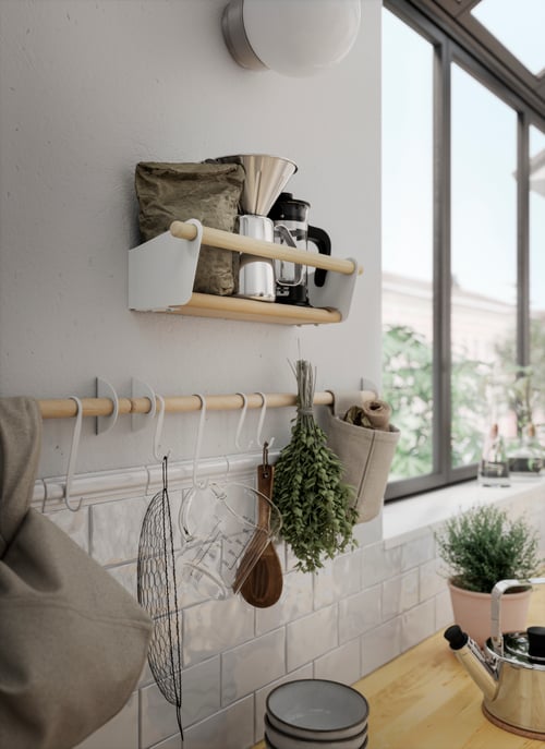 Bucătărie tradițională aproape de un raft de perete bej cu design rustic deasupra unei șine bej cu mai multe cârlige în formă de S.