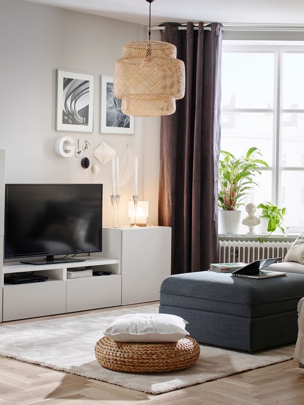 A BACKSÄLEN 3-seat sofa in a natural tone, cosy lighting from a floor lamp and a pendant lamp and a rug in natural fibre.