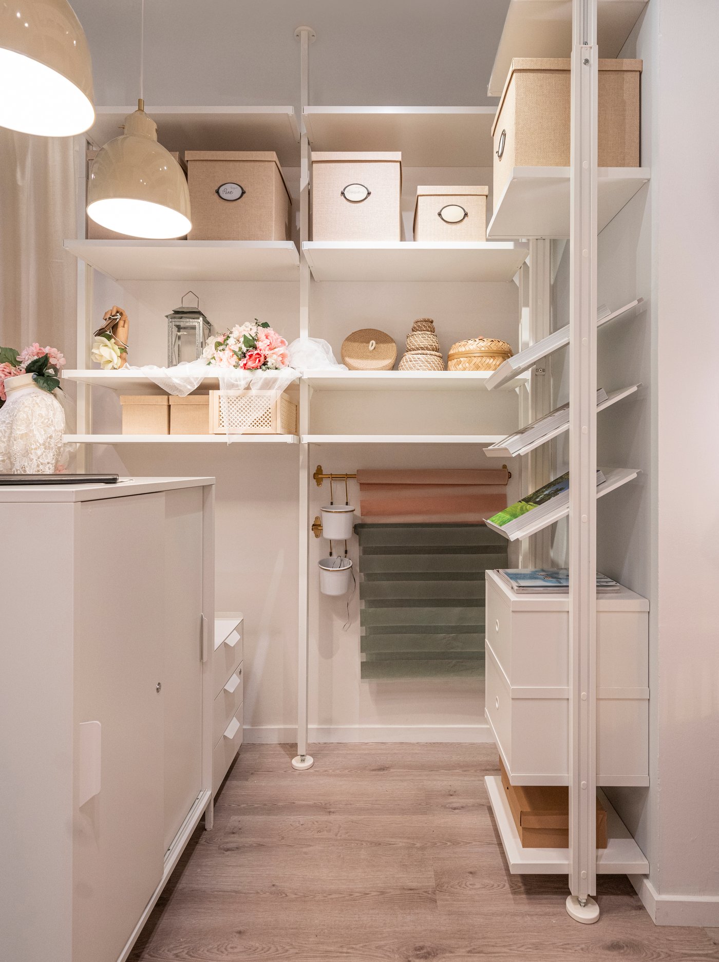 Combinazione di scaffali ELVARLI nel retro bancone utilizzati per esporre e organizzare il negozio.