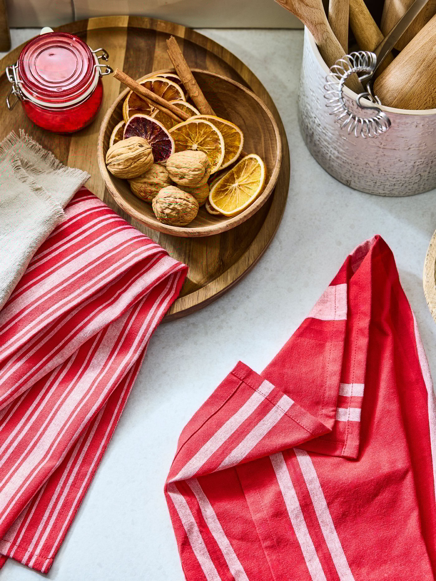 Paños de cocina rojos con blanco VINTERFINT junto a plato de madera.
