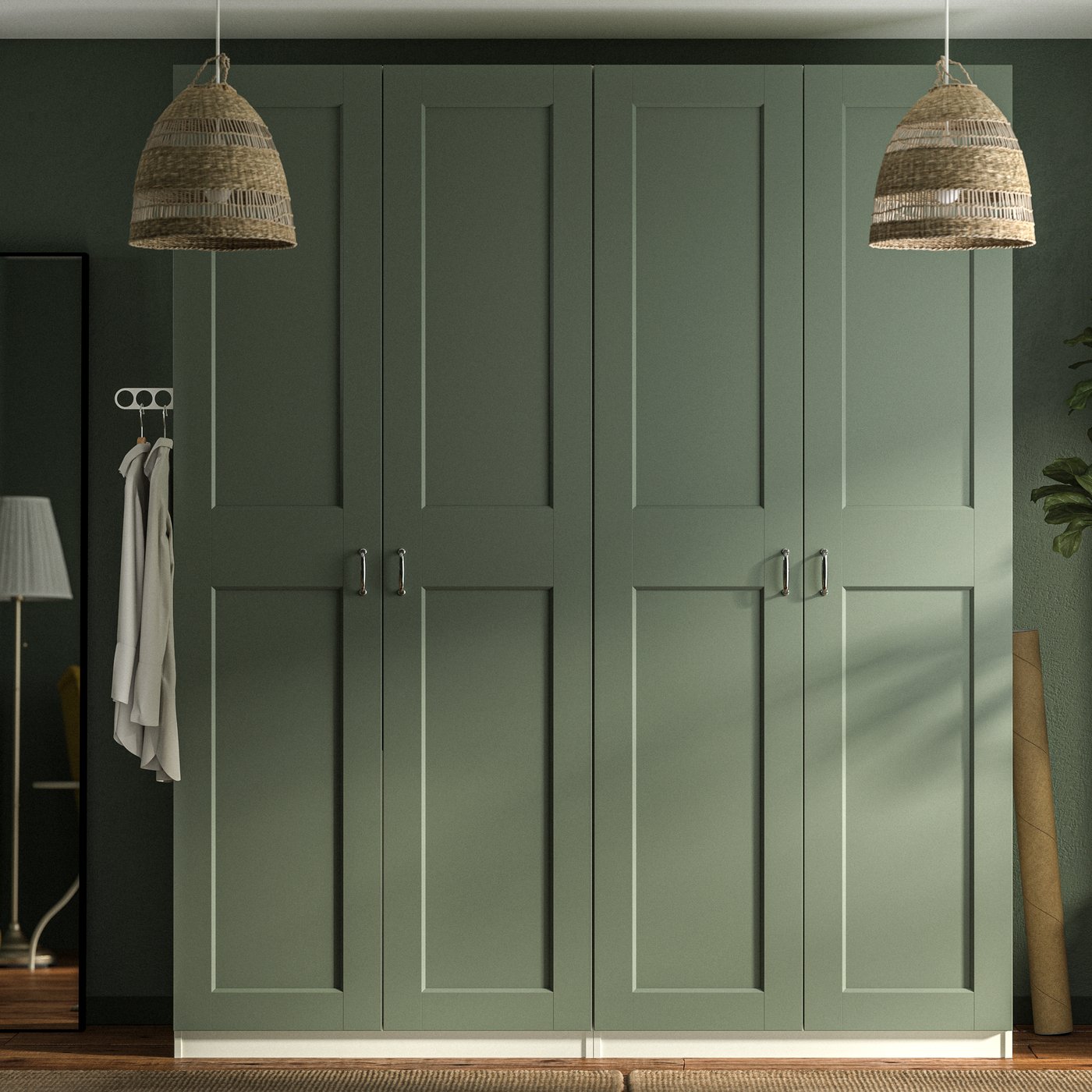 Szafy PAX z szarozielonymi drzwiami GRIMO na tle ściany w pasującym odcieniu zieleni oraz dwie lampy wiszące TORARED wykonane z turzycy.
