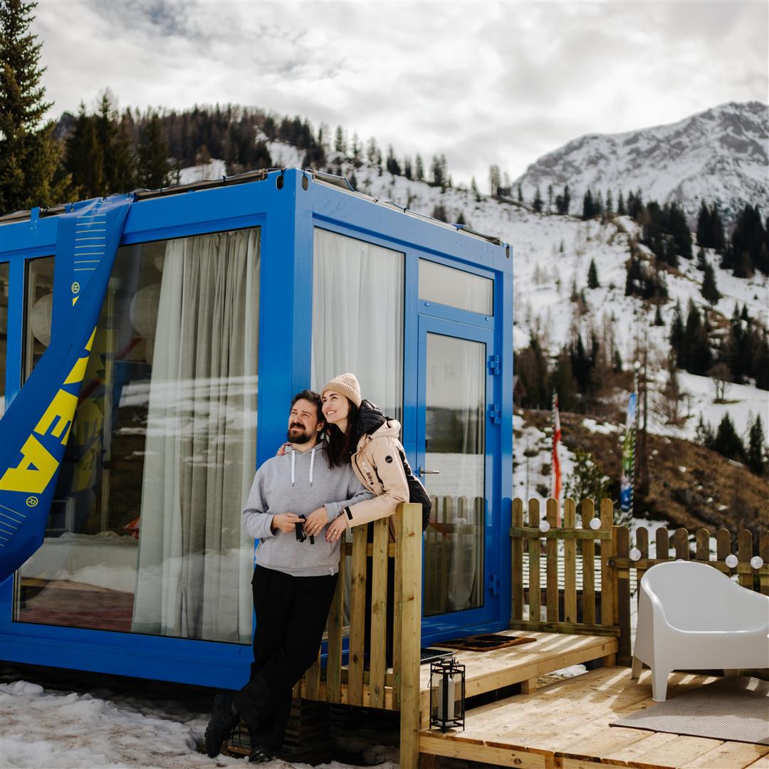 Gewinnerpaar des IKEA Family Schlummertaschen Gewinnspiels stehen vor der Schlummertasche und genießen den Ausblick in die Salzburger Berge