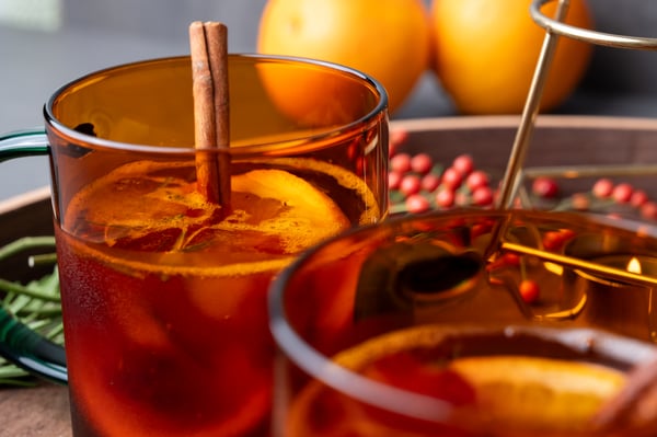 Sparkling Lingonberry Punsch in einem roten Glas auf einem Serviertablett aus Holz angerichtet.