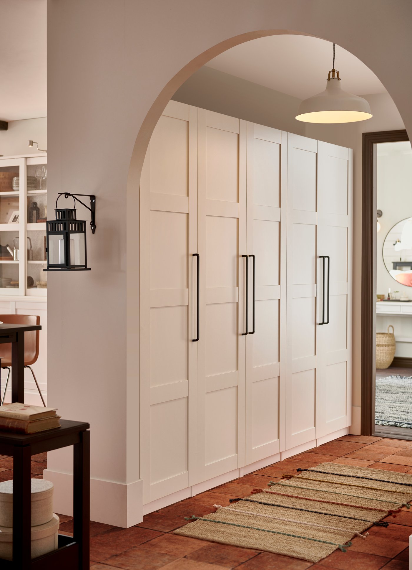 Ein weißer Pax Kleiderschrank an einer Wand mit geschlossenen Türen.