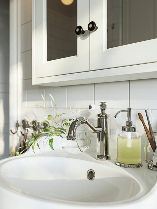 Bathroom close-up of a TÄNNFORSEN wash stand with wash basins and taps, a BALUNGEN soap dispenser and a VILJESTARK vase.