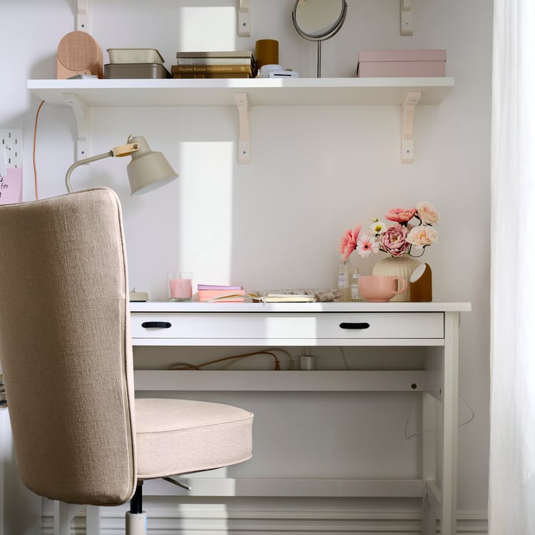 A study area with a white wall shelf and neatly organised stationery