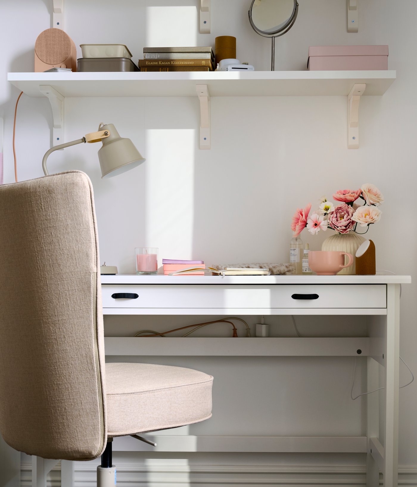 A study area featuring a white BERGSHULT wall shelf made from white stained aspen, neatly displaying stationery and decor.
