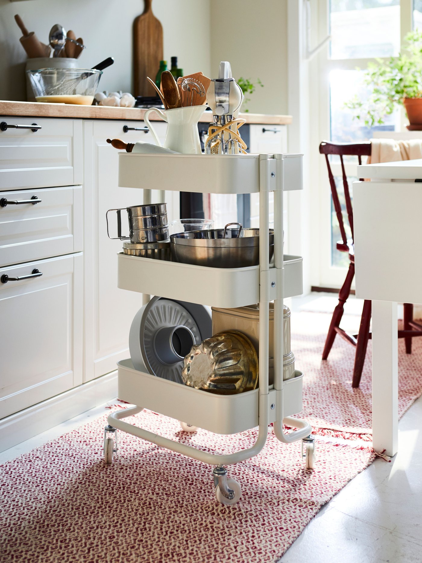 A white RÅSKOG trolley in the kitchen