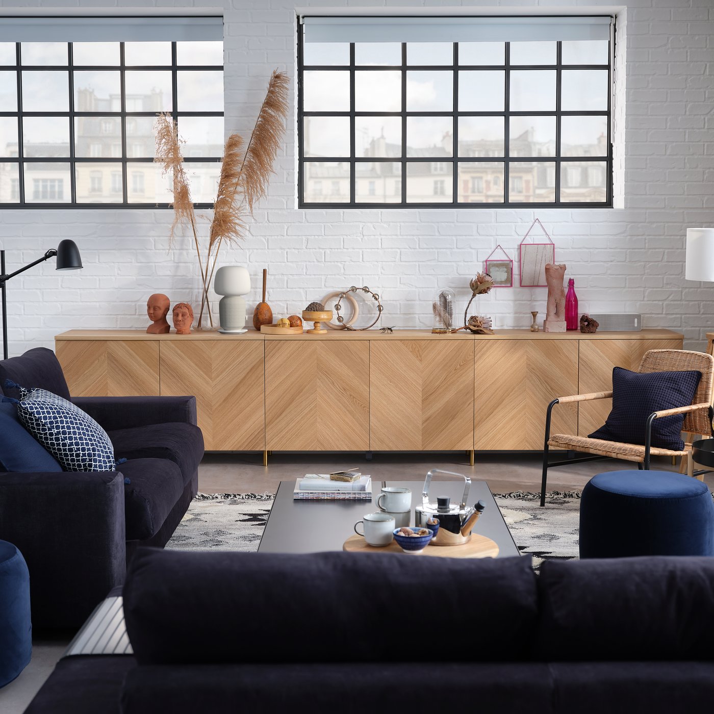 Design-Wohnzimmer mit 3er-Sofa, 2er-Bettsofa, Aufbewahrungskombination mit Türen und einem Sessel.