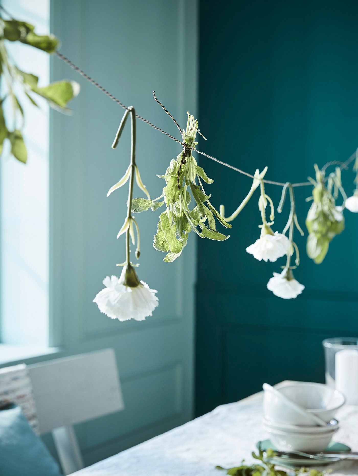 ثلاث شموع كتلة معطرة BEHJÄRTAD على صينية BEGÄRAN على طاولة KRAGSTA مع صوفا FÄRLÖV في الخلفية.