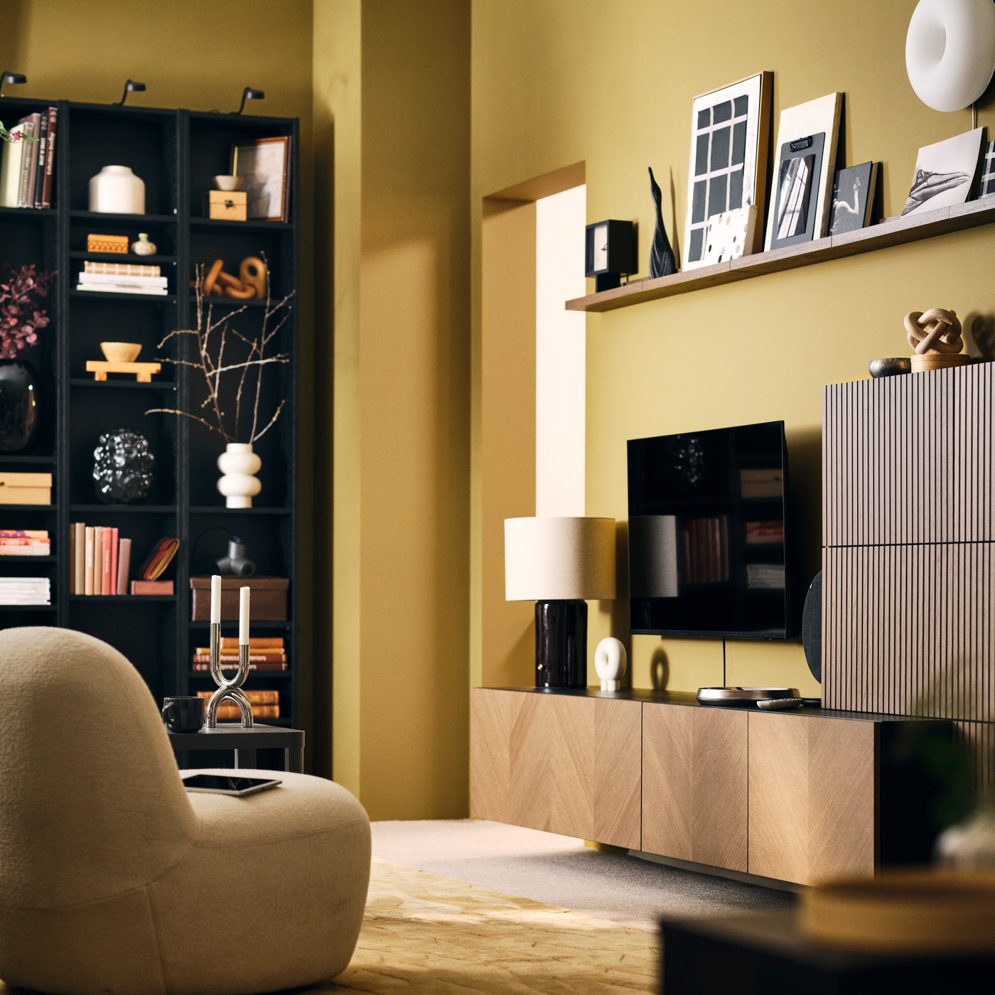 A neat, light living room with a BESTÅ storage combination with wood-veneer fronts, bookshelves and an easy chair.