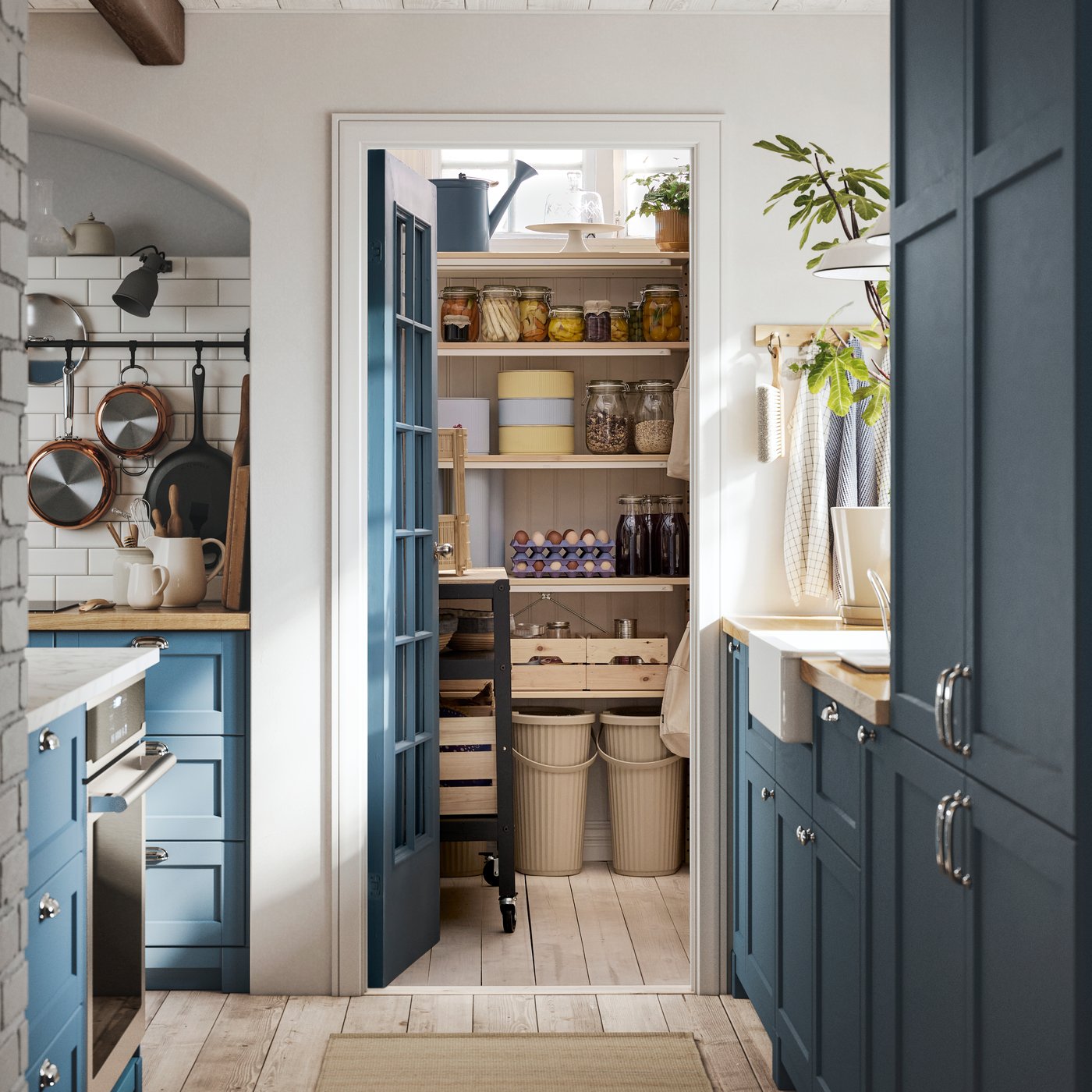 A SEKTION kitchen with LERHYTTAN blue fronts has a blue door that opens up to a pantry with several IVAR shelving units.