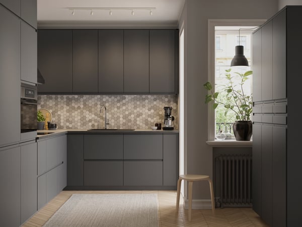 Un mobile base angolare VOXTORP grigio scuro a 2 ante a destra in cucina.