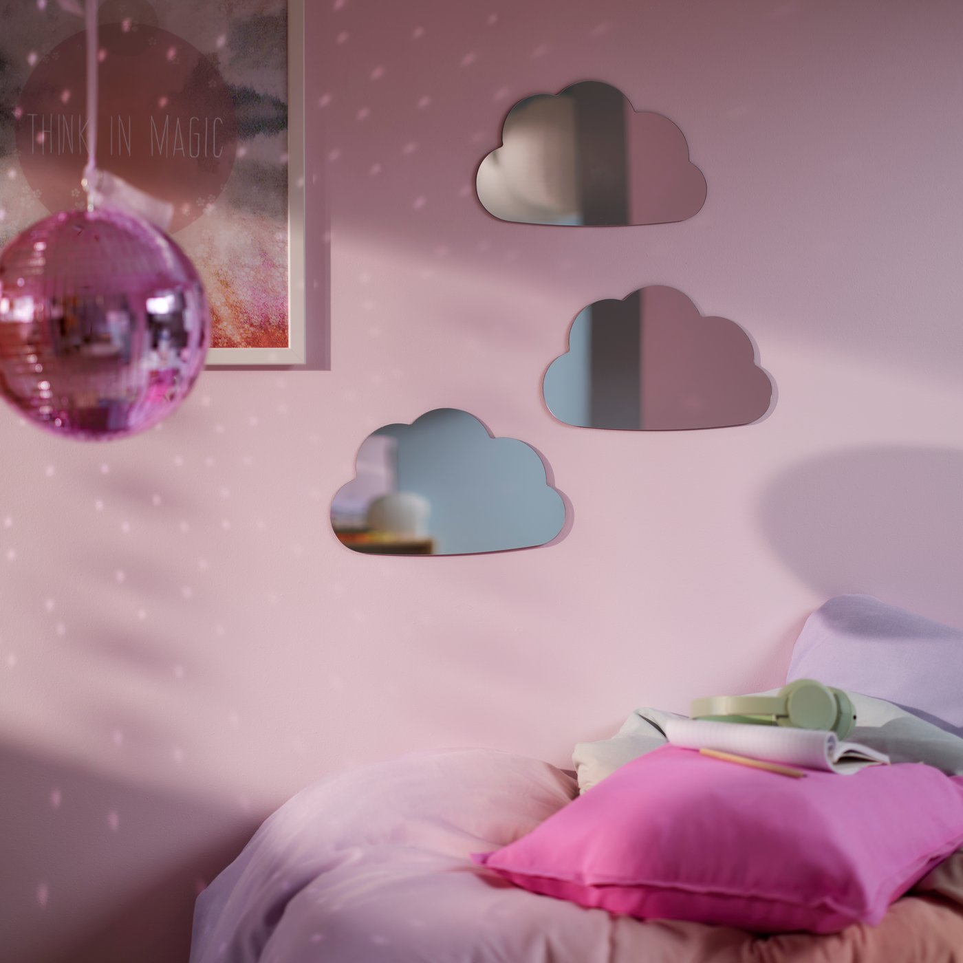 An einer rosa Wand sind Spiegel in Wolkenform zu sehen