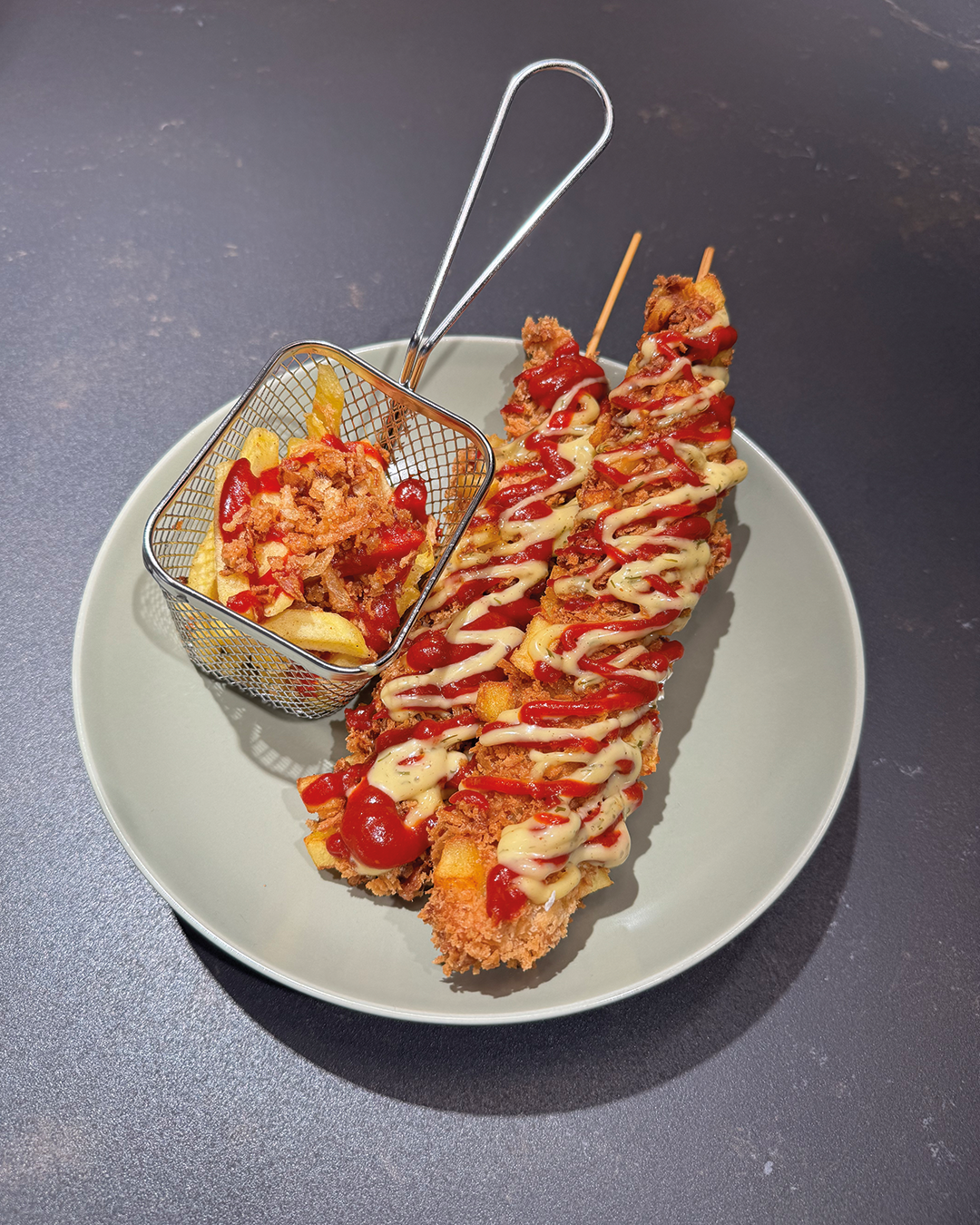 KOREAN CORN DOGS mit Gochujang-Ketchup & Sas Senap Kewpie Mayo auf einem Teller präsentiert.KOREAN CORN DOGS mit Gochujang-Ketchup & Sas Senap Kewpie Mayo auf einem Teller präsentiert.
