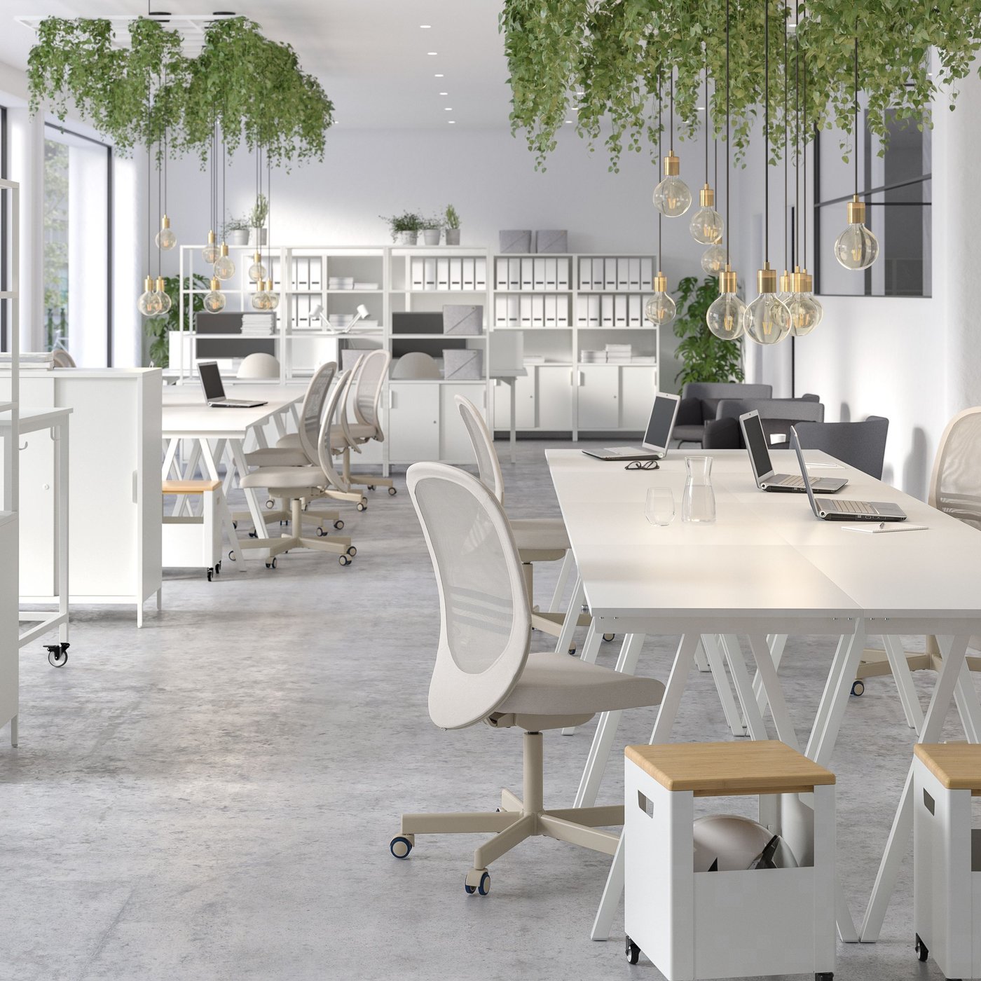 Several TROTTEN desks grouped together with a TROTTEN storage unit on castors in the front.