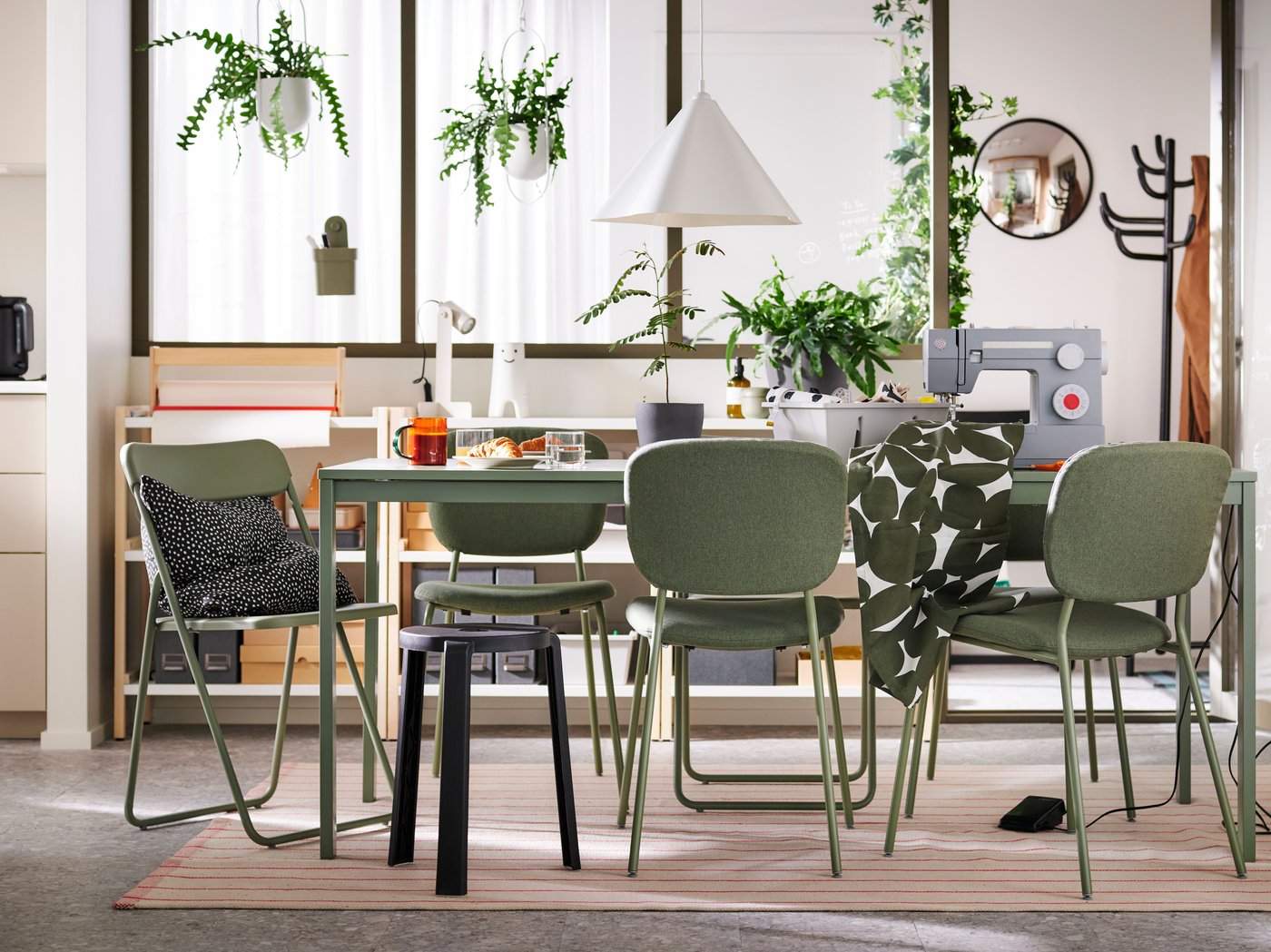 VIHALS chairs and a stool stand at a green VIHALS extendable table on a rug in a multifunctional dining room.