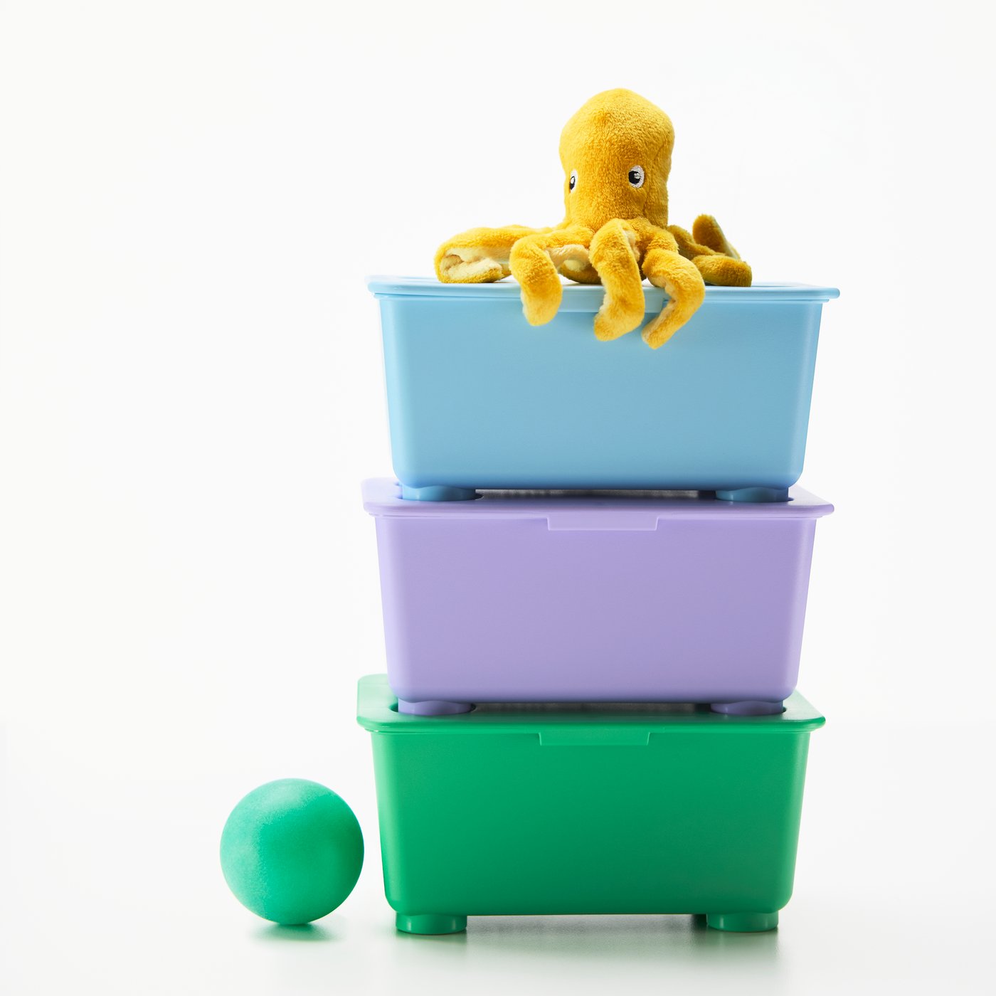 A stack of three GLIS storage boxes with lid. On top, a small, yellow toy octopus holding a little cocktail umbrella.