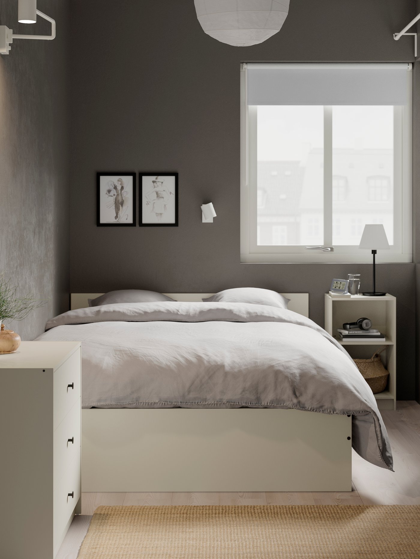 Dormitorio con somier beige con cabecero de madera colocado junto a una mesilla de noche y una cómoda de 3 cajones.