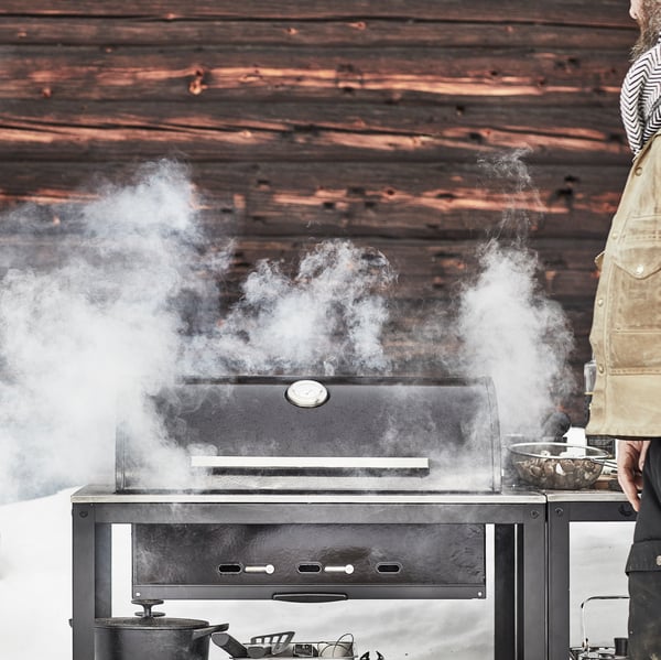 A black/stainless steel outdoor GRILLSKÄR charcoal barbecue