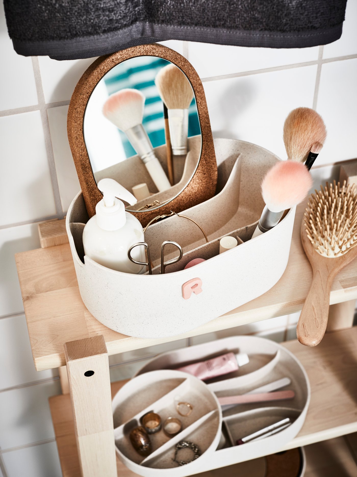 Platikowy pojemnik z lustrem SAXBORGA wypełniony kosmetykami.