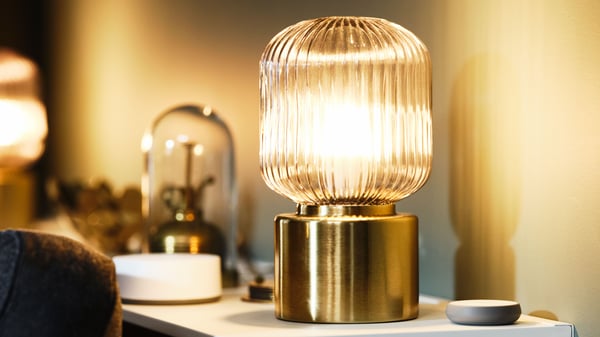 A brass/grey clear glass SOLKLINT table lamp in the living room