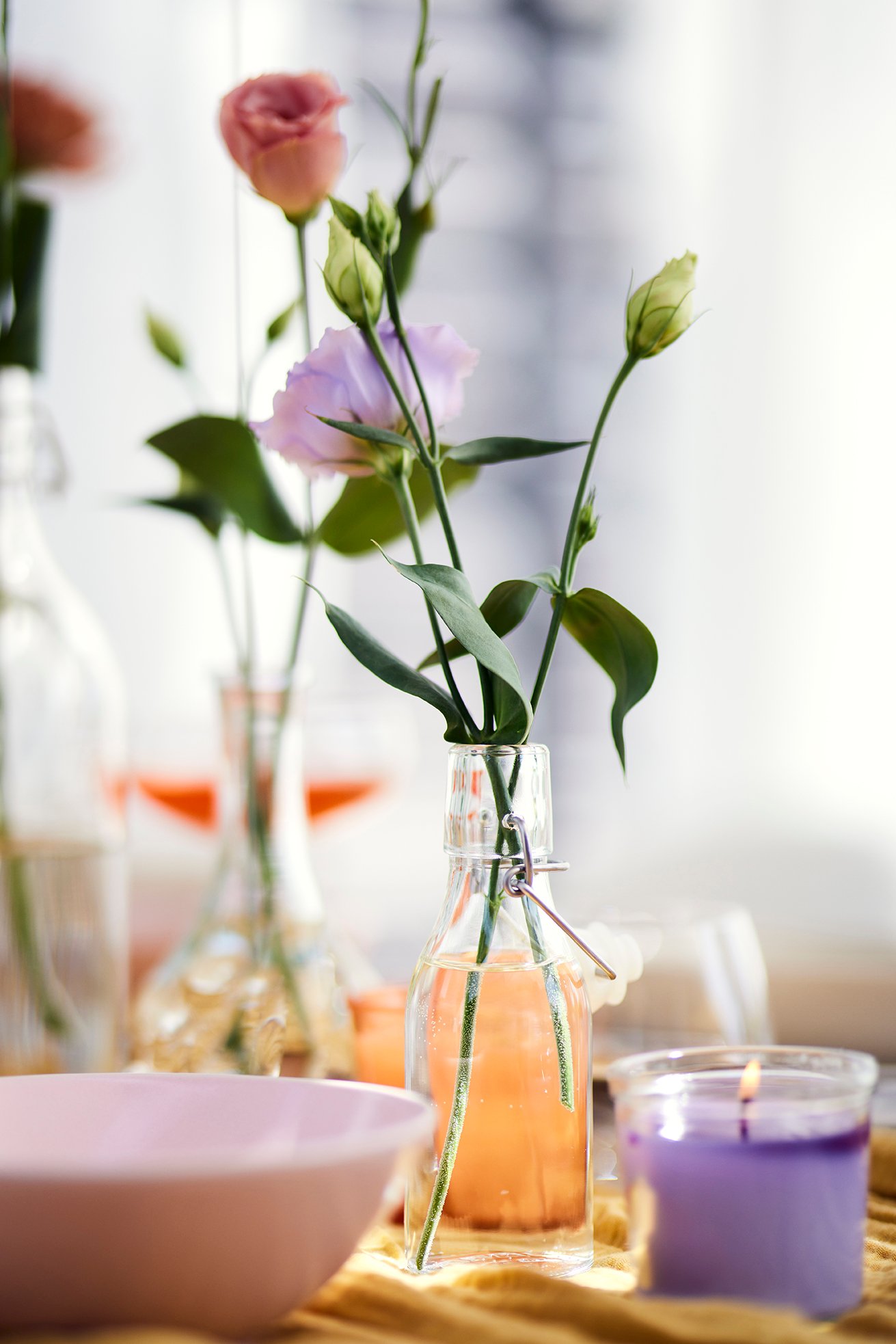 Nahaufnahme einer kleinen Bügelflasche in der drei Blumen stehen