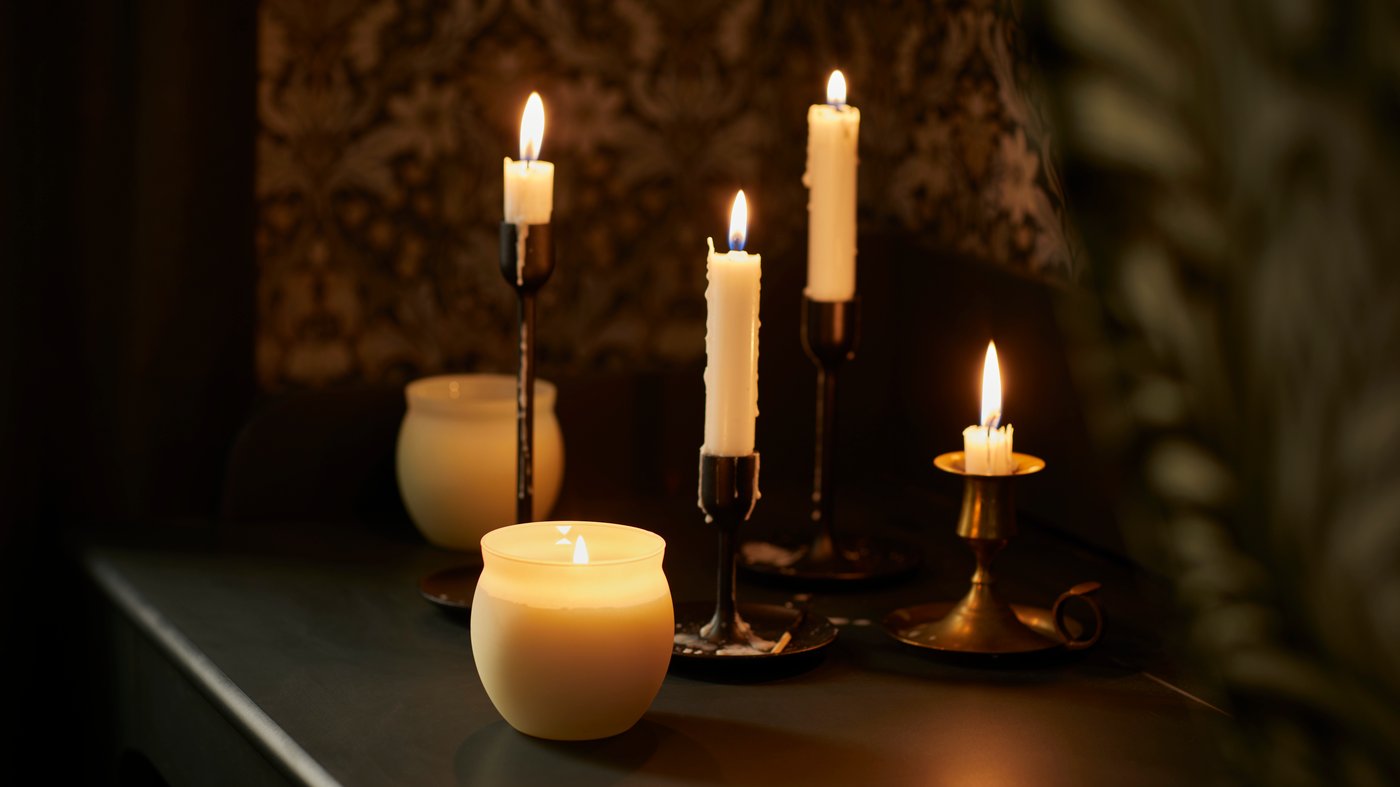 Vanília/világosbézs színű JÄMLIK illatgyertya üvegben.