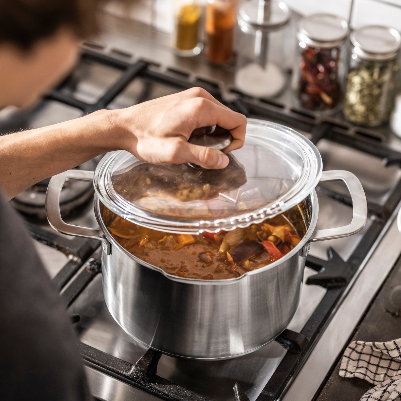 En HEMKOMST-gryte i rustfritt stål/glass med lokk.