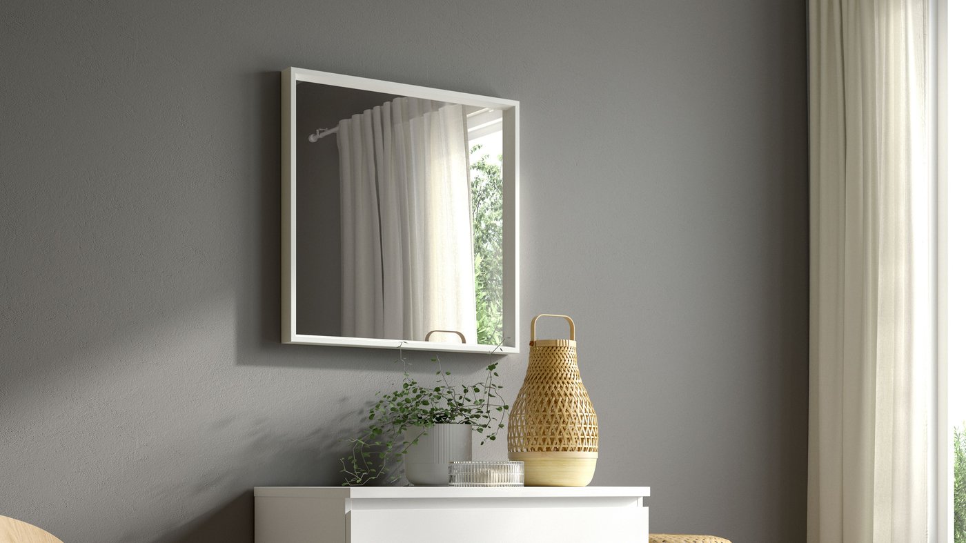 A white square NISSEDAL mirror above a chest of drawers against a grey wall.