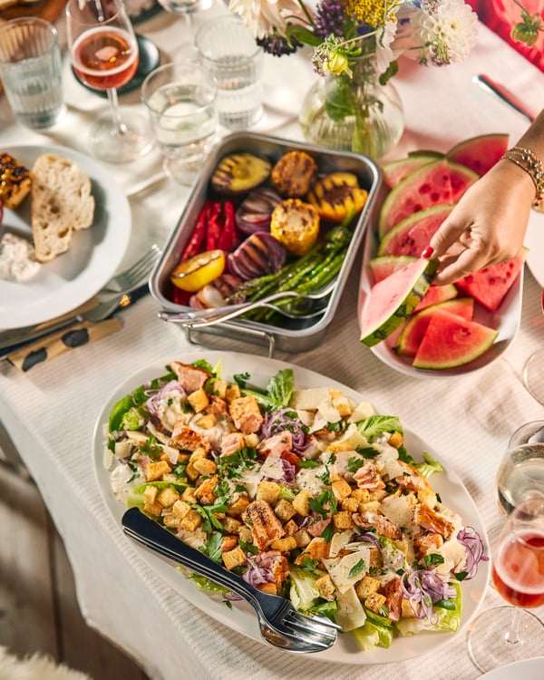 A table with a white tablecloth filled with different dishes.