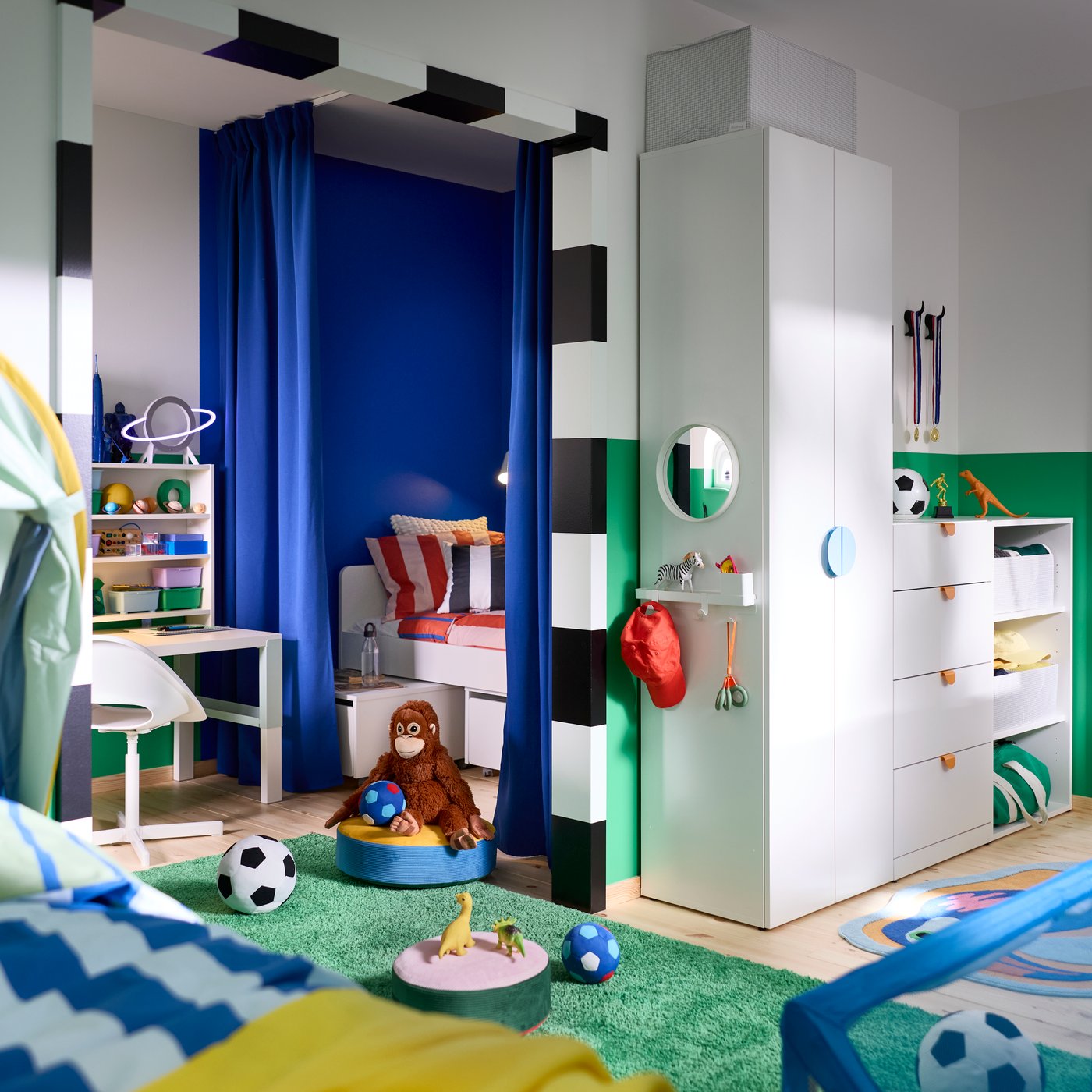 LASTARE wardrobe combination with drawers, open storage and hooks in a kids’ room with toys, books and sports items.
