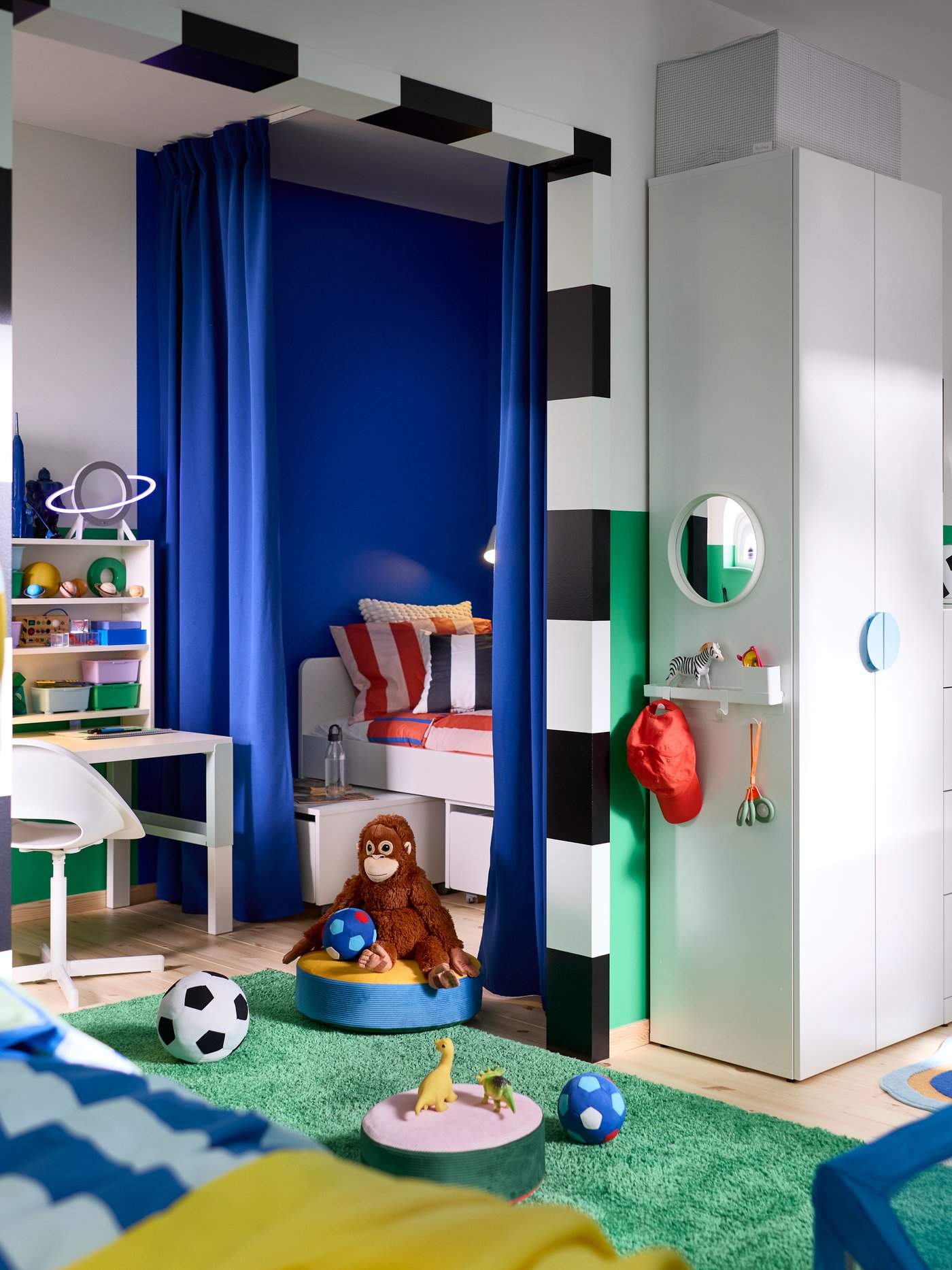 LASTARE wardrobe combination with drawers, open storage and hooks in a kids’ room with toys, books and sports items.