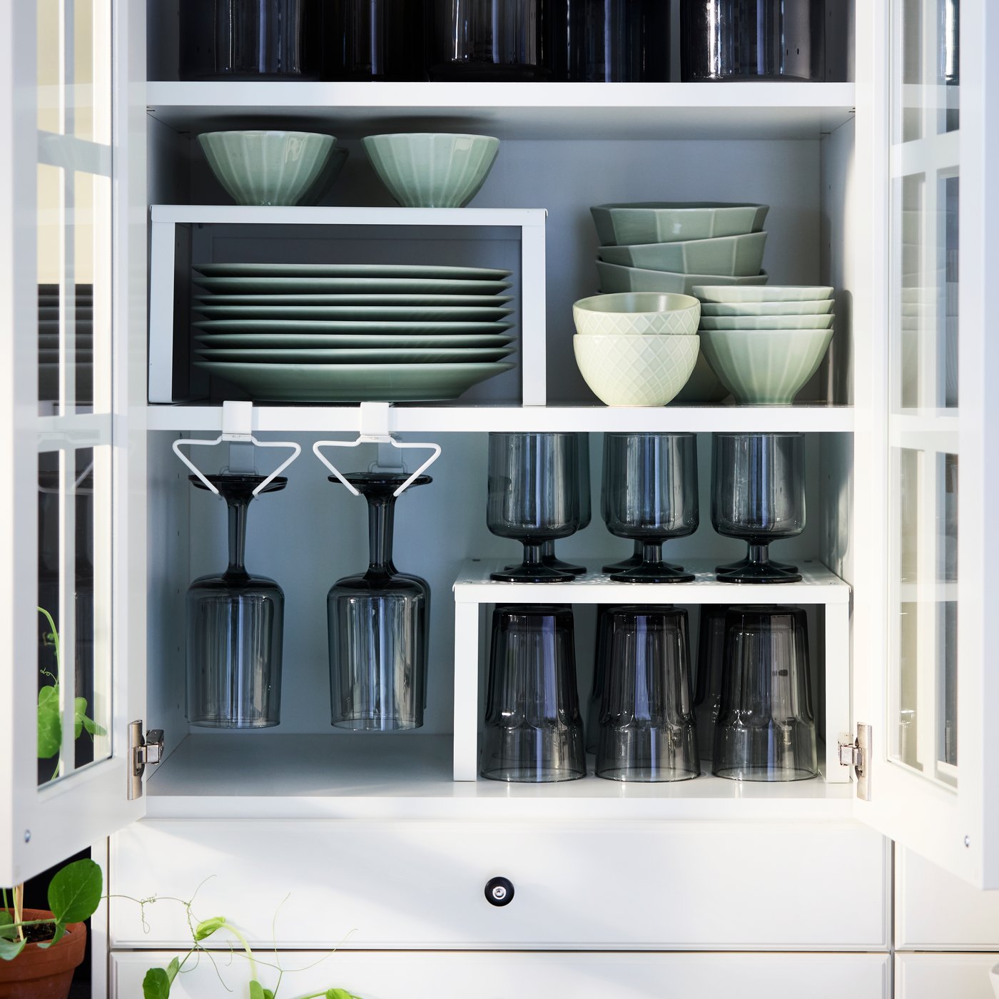 A neatly arranged kitchen wall cabinet fitted with PÅLYCKE and VARIERA organisers containing tableware and drinking glasses.