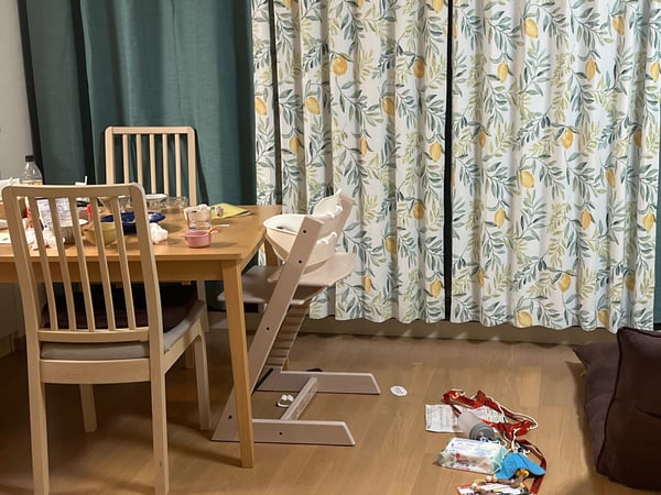 ダイニングテーブルと床の上に物が散乱している様子