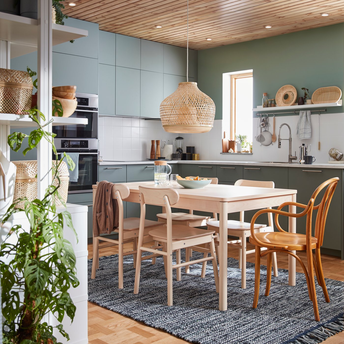 Ein Esstisch aus Birkenholz umgeben von fünf Stühlen aus Holz in einer gemütlichen Küche.