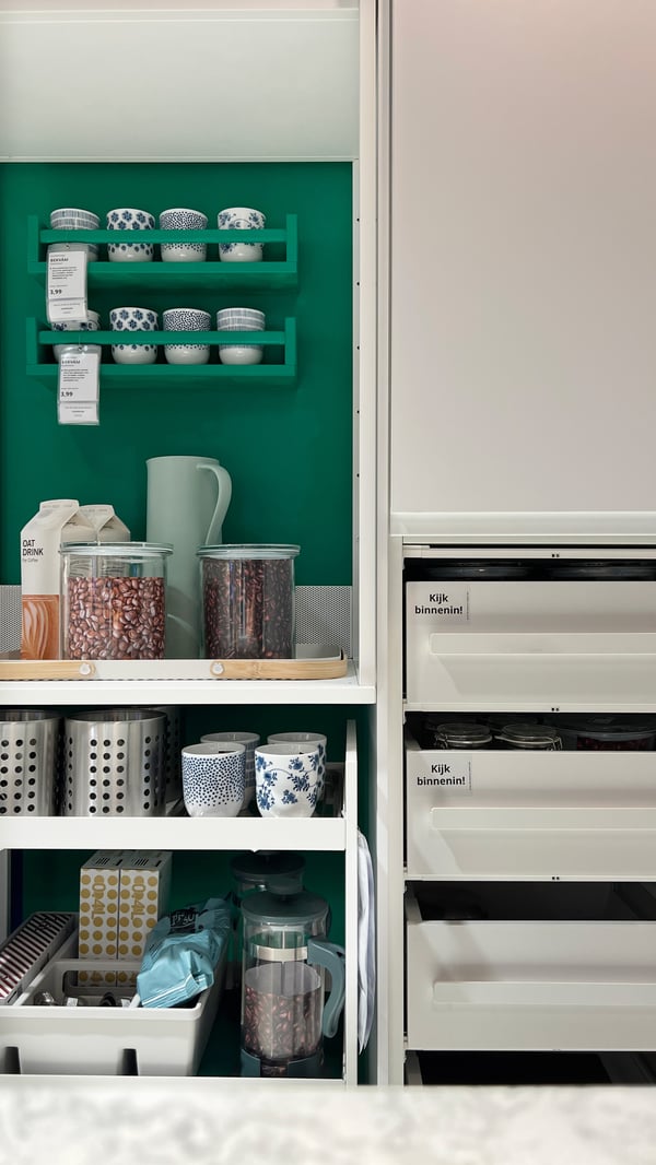 An extendable table with coffee utensils next to a kitchen cabinet with drawers