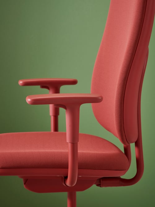 A red SMÖRKULL office chair with armrests placed on a green background.