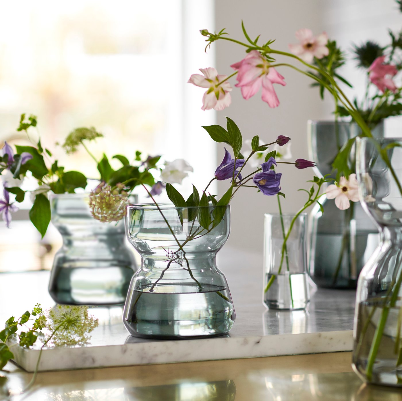 A close-up of two watercolour paint tubes and a piece of paper lying in an ERTAPPAD dish in blue on a table corner.