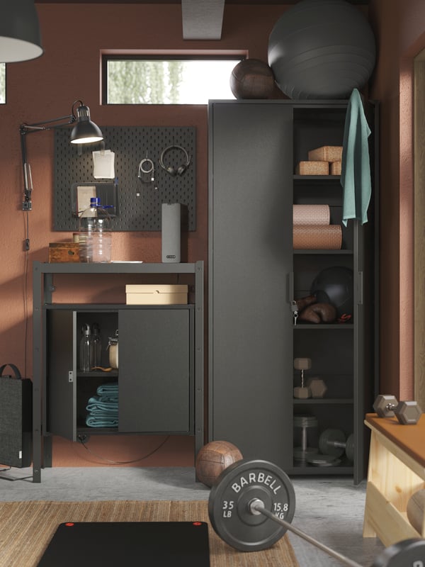 A garage interior with things kept tidy by a black shelving-unit-and-cabinet BROR combination and a black SKÅDIS pegboard.